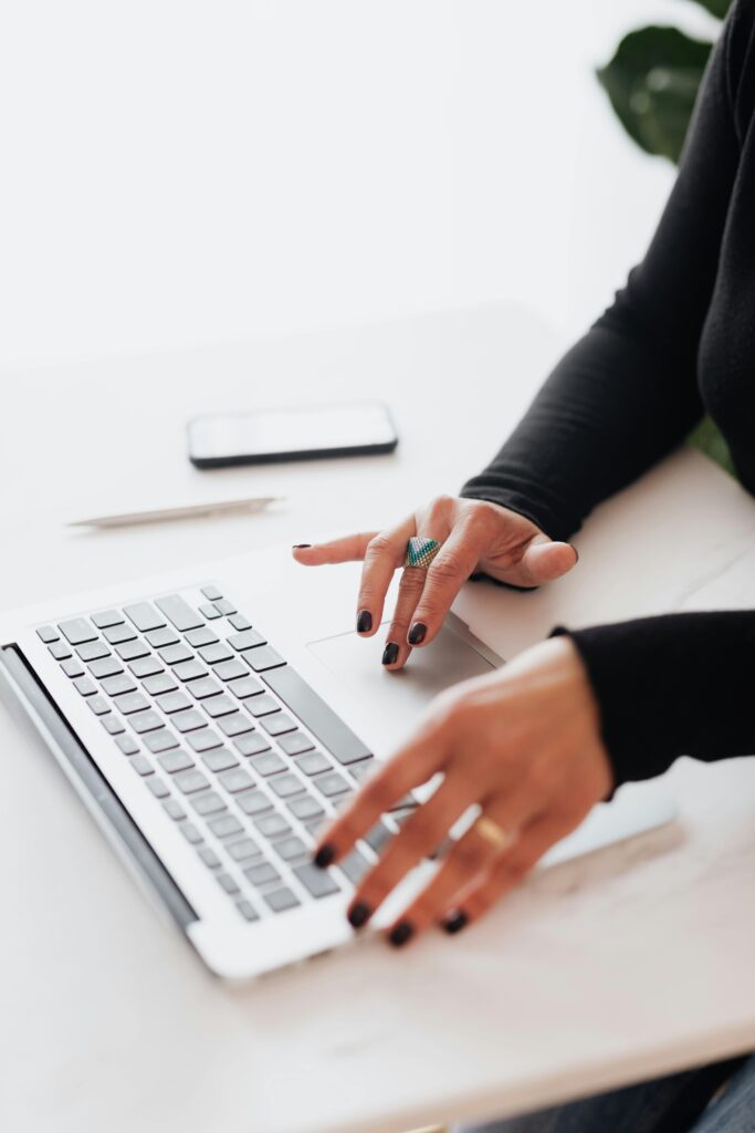 pexels-photo-4467739-4467739 A businesswoman's hands typing on a laptop at a bright, modern workspace.